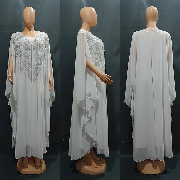 Elegant woman wearing a Plus Size African Dress featuring intricate embroidery, showing the flowing chiffon design in a stylish setting.