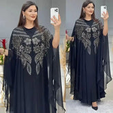 Elegant woman wearing a Plus Size African Dress featuring intricate embroidery, showing the flowing chiffon design in a stylish setting.